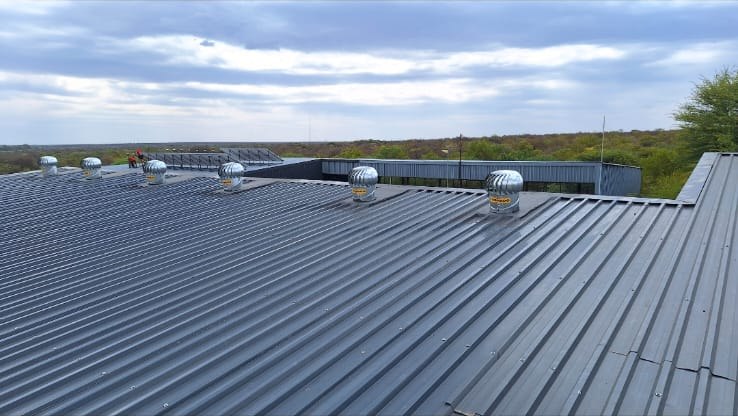 Commercial metal roof with ventilation turbines by Perfect Peaks