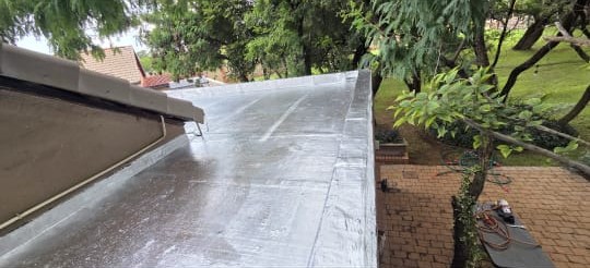 Silver waterproof coating on a flat roof by Perfect Peaks